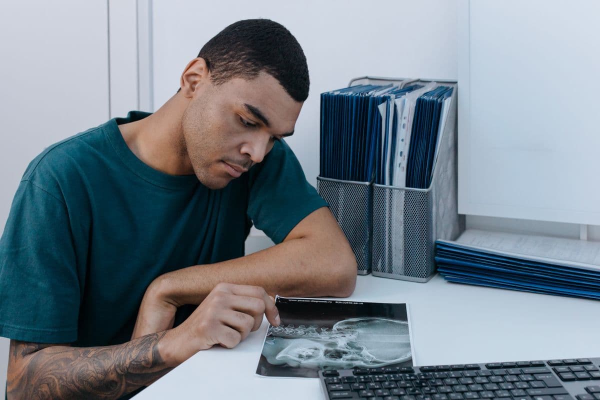 Clinician analyzing a panoramic dental X-ray on a monitor for implant planning