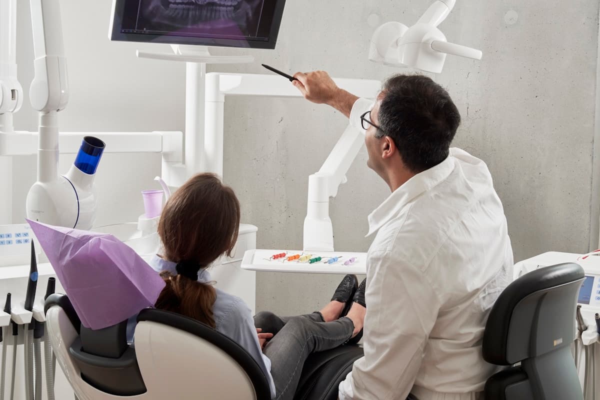 Dentist reviewing a panoramic dental X-ray with a patient during case consultation
